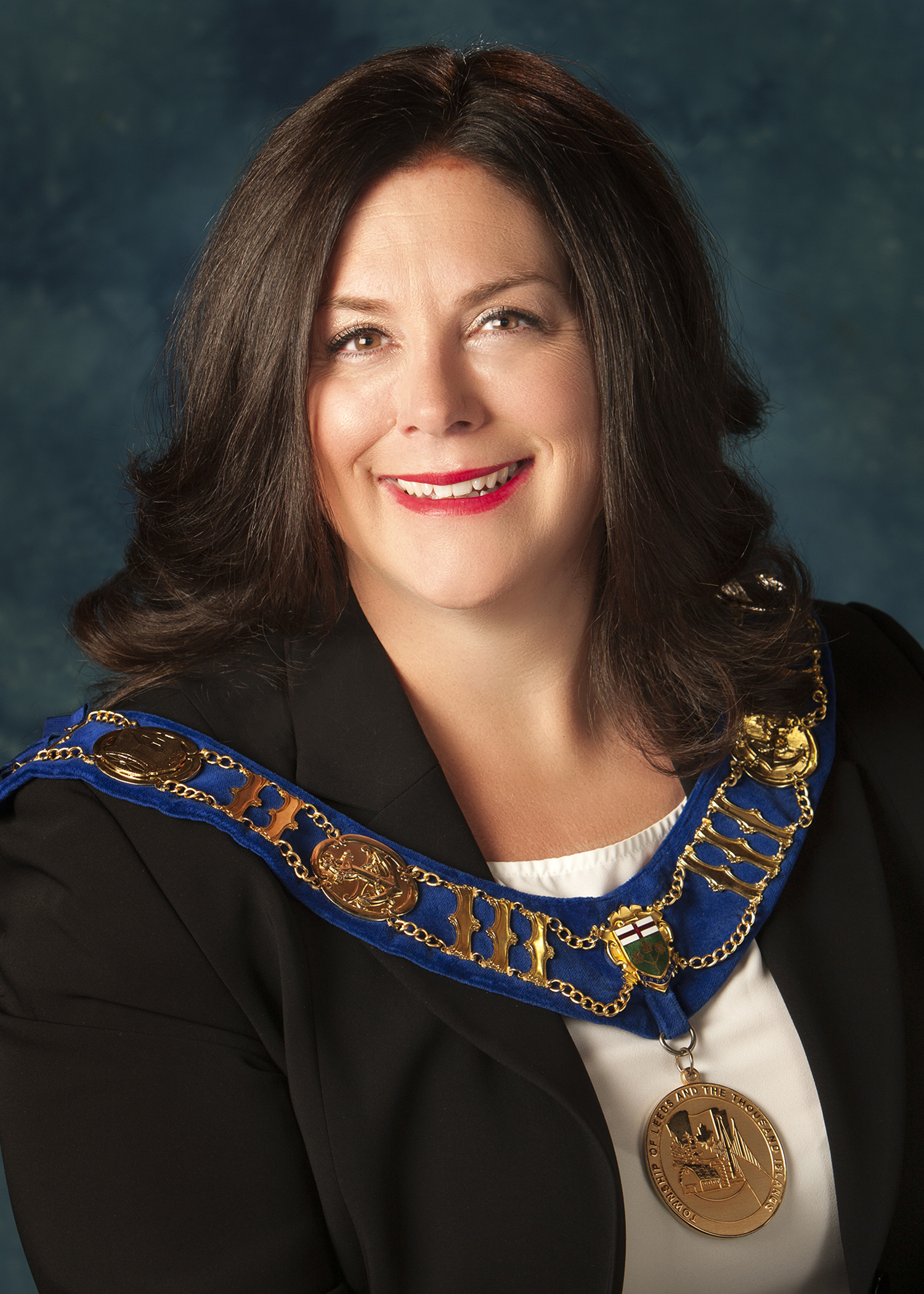 Headshot of women with long brown hair wearing the mayoral chain of office