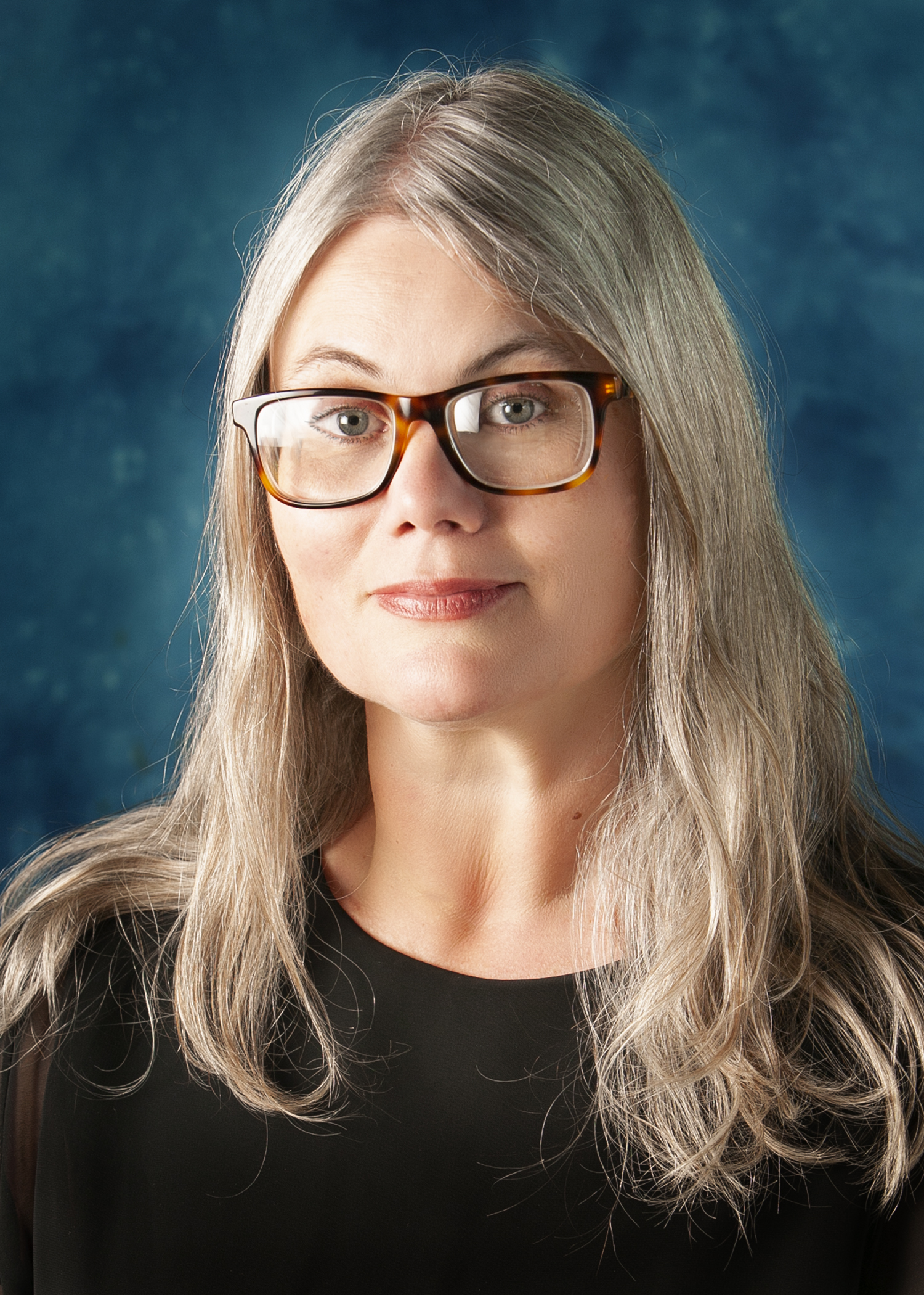 Headshot of woman with glasses and long blond hair