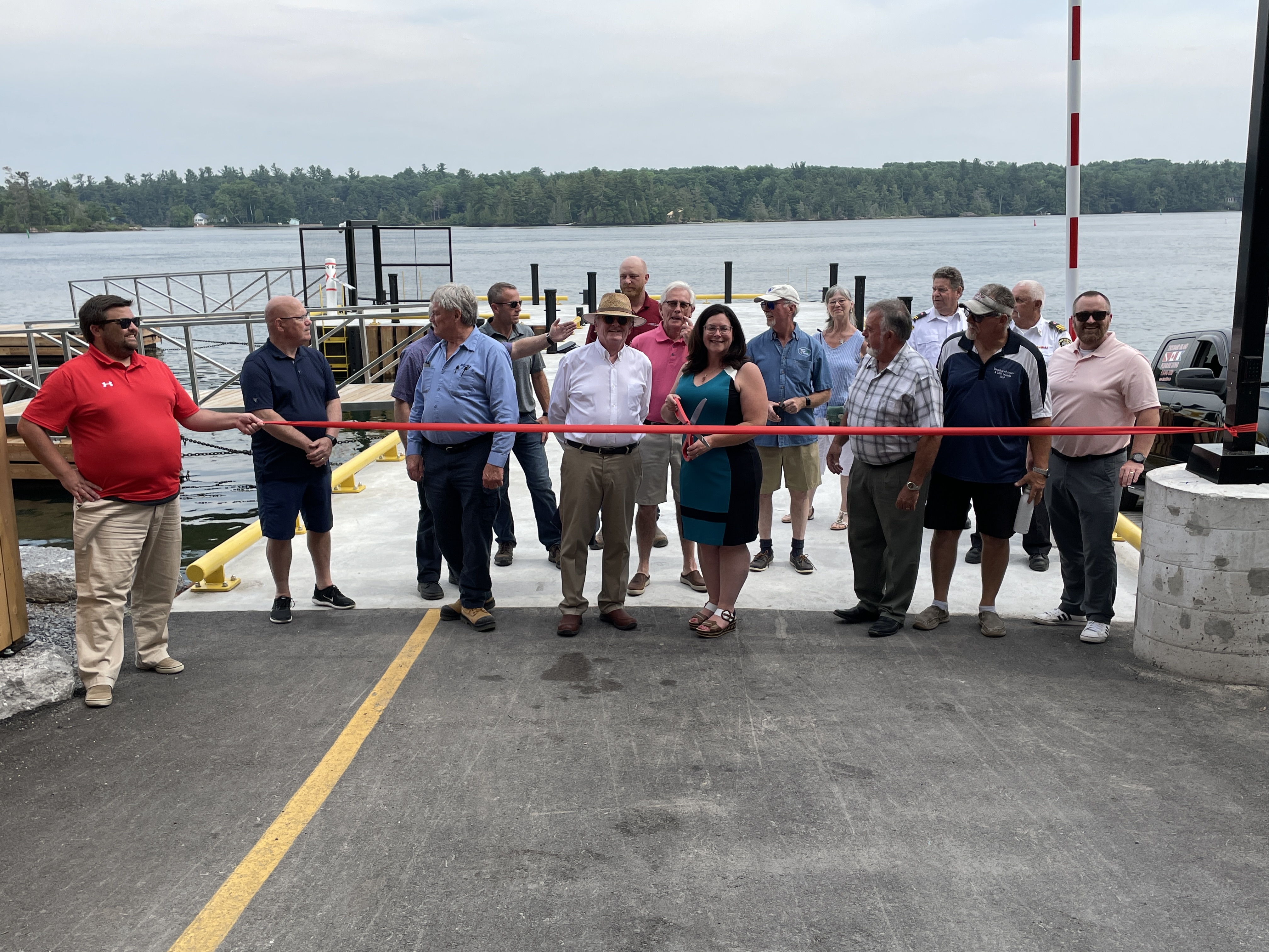 Ivy Lea Wharf with people standing on the whafr holding a ribbon for a ribbon cutting cermony